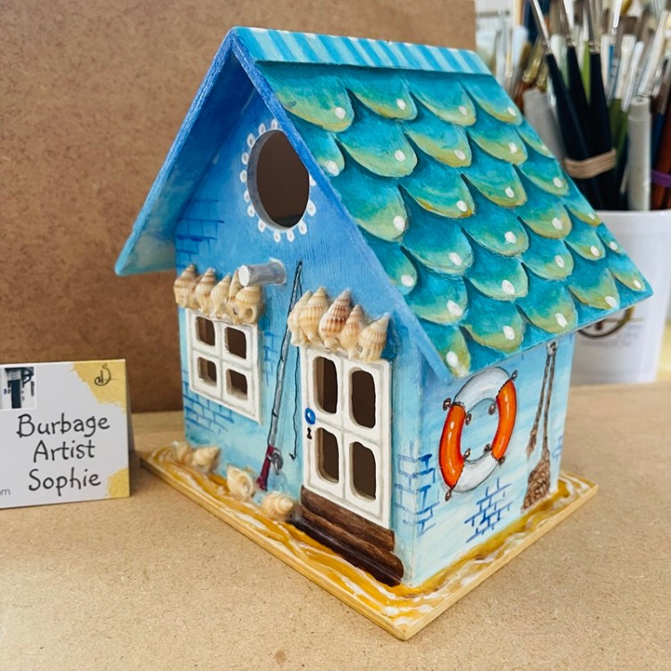photo showing the hand painted bird house at an angle, at burbage artist sophie art studio